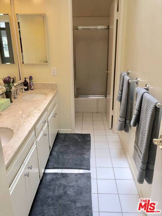 9601 Heather Road Beverly Hills, CA 90210 - Photo 16 of 21 a bathroom with a sink and mirror