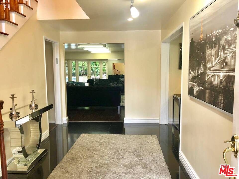 9601 Heather Road Beverly Hills, CA 90210 - Photo 17 of 21 a view of hallway with a couch and wooden floor