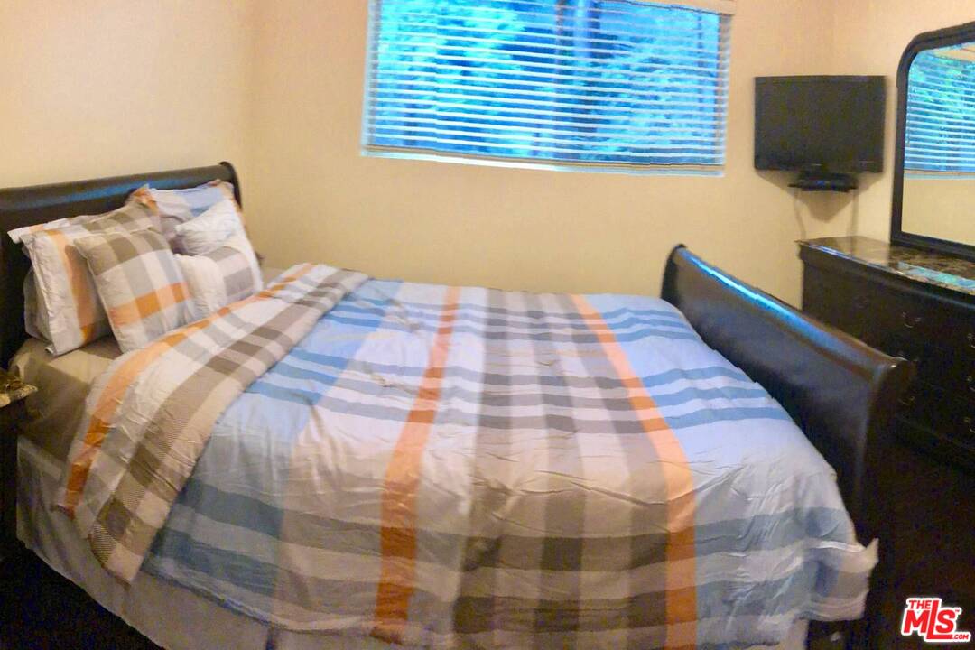 9601 Heather Road Beverly Hills, CA 90210 - Photo 18 of 21 a bedroom with a bed and a flat screen tv