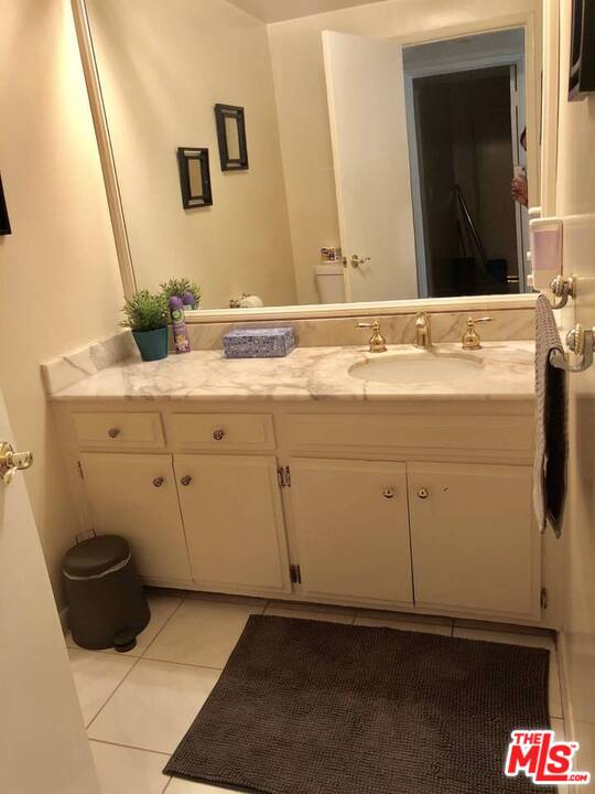 9601 Heather Road Beverly Hills, CA 90210 - Photo 19 of 21 a bathroom with a sink and a mirror