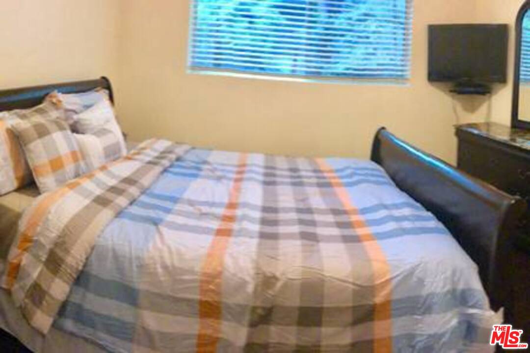 9601 Heather Road Beverly Hills, CA 90210 - Photo 20 of 21 a bedroom with a bed tv and a window