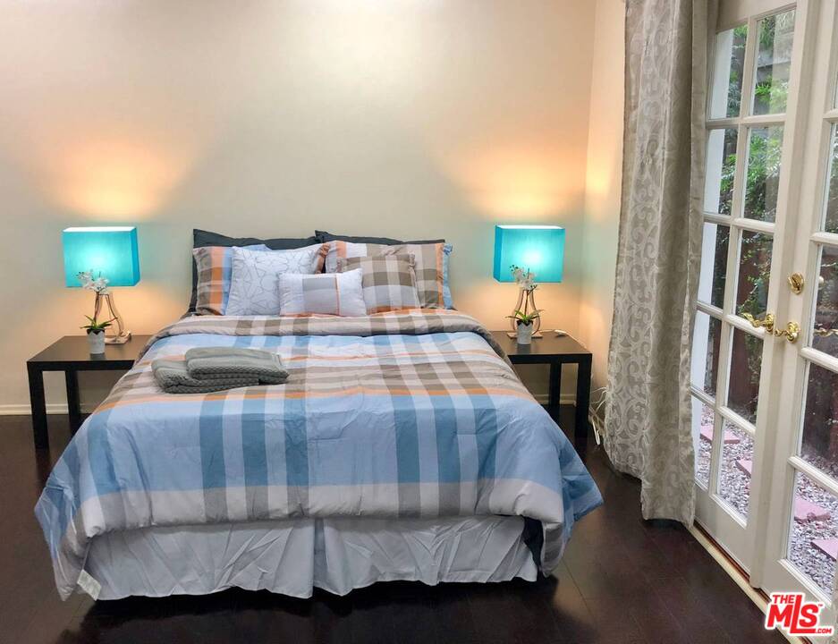 9601 Heather Road Beverly Hills, CA 90210 - Photo 8 of 21 a bedroom with a bed and a lamp