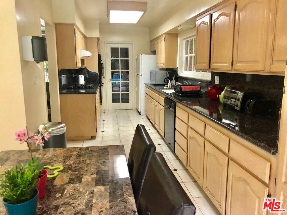 9601 Heather Road Beverly Hills, CA 90210 - Photo 10 of 21 a kitchen with stainless steel appliances a microwave a stove and refrigerator