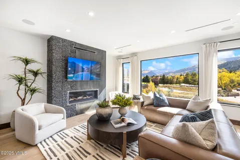 a living room with fireplace furniture and a large window