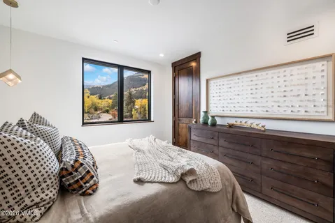 a bedroom with a bed and a large mirror on dresser