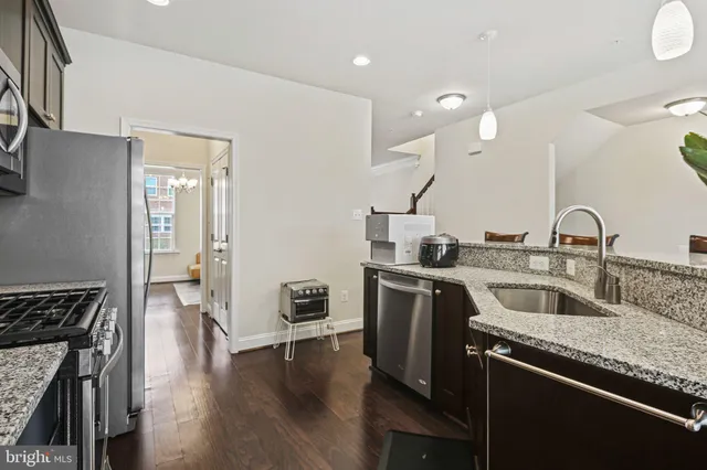 a kitchen with a sink cabinets and wooden floor