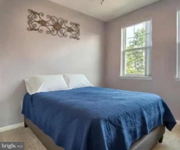 a large bed sitting in a bedroom next to a window