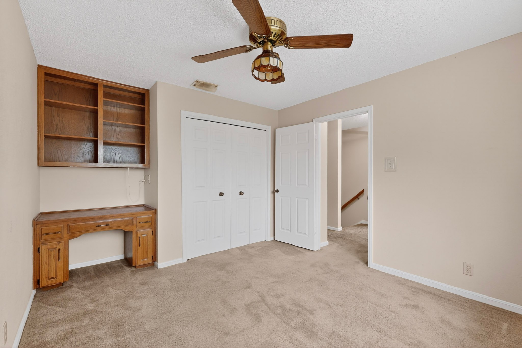 1003 Pier Branch Road Dripping Springs, TX 78620 - Photo 27 of 40 Well-lit room features built-in shelving, a dedicated desk area, and plush carpeting.