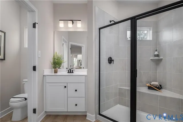 a bathroom with a shower sink vanity and toilet