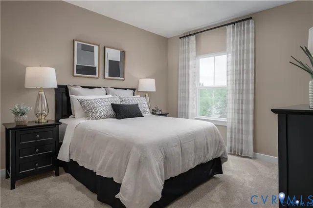 a bedroom with a bed and a lamp on dresser