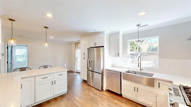 a kitchen with white cabinets and window