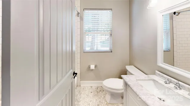 an empty room with windows fireplace and wooden floor