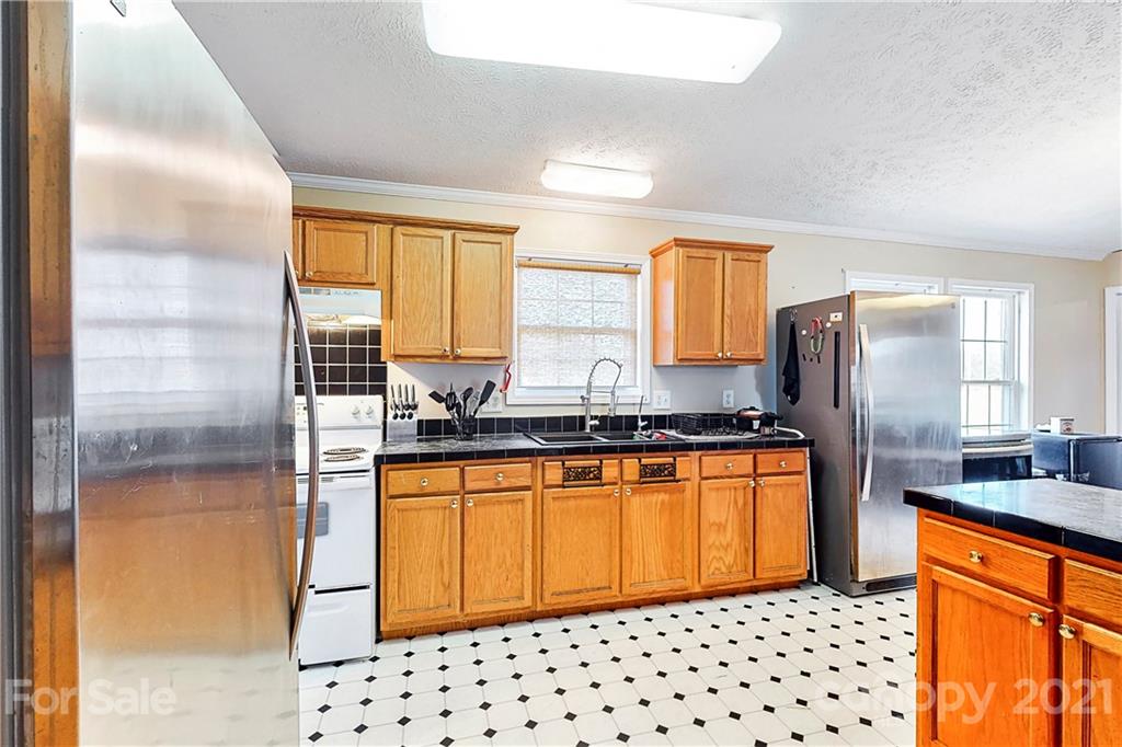 4407 Wolf Pond Road Monroe, NC 28112 - Photo 11 of 26 a kitchen with stainless steel appliances granite countertop a stove a sink and a refrigerator