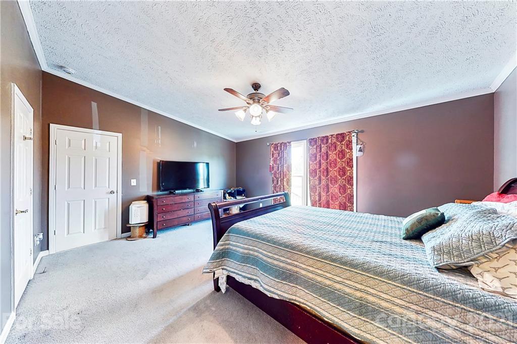 4407 Wolf Pond Road Monroe, NC 28112 - Photo 18 of 26 a bedroom with a bed and a chandelier with window