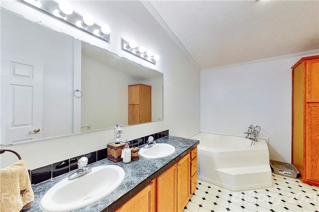 4407 Wolf Pond Road Monroe, NC 28112 - Photo 19 of 26 a bathroom with a granite countertop sink and a mirror