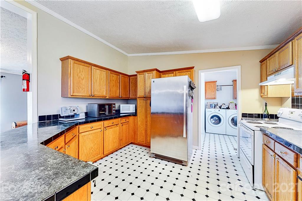 4407 Wolf Pond Road Monroe, NC 28112 - Photo 10 of 26 a kitchen with granite countertop a sink a stove and refrigerator