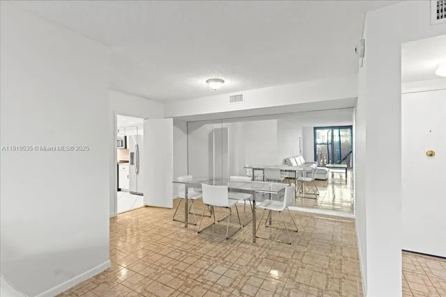 a living room with chairs and a table with rug