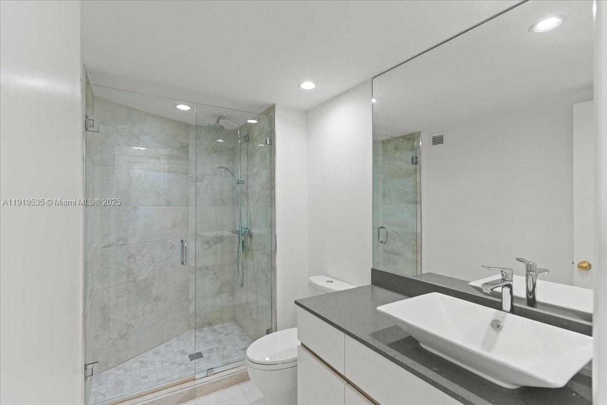 1121 Crandon Boulevard, Unit E304 Key Biscayne, FL 33149 - Photo 6 of 17 a bathroom with a sink a toilet and shower