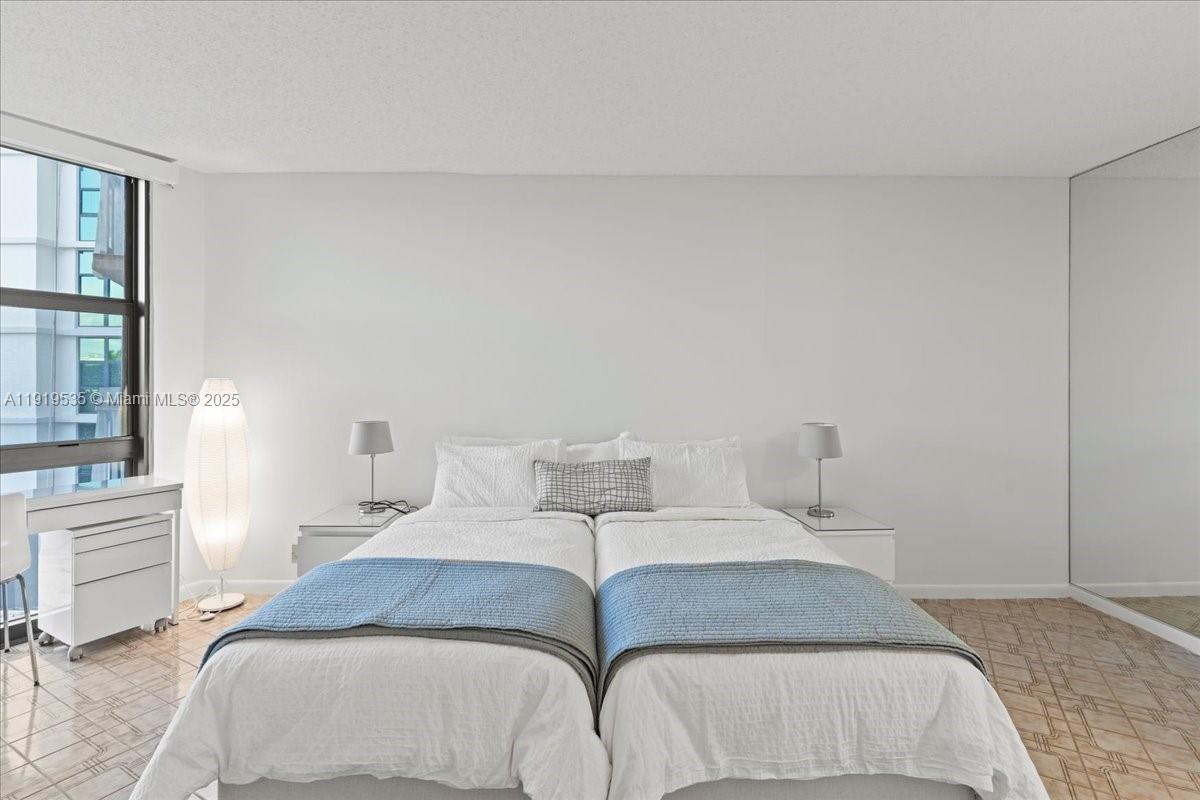 1121 Crandon Boulevard, Unit E304 Key Biscayne, FL 33149 - Photo 7 of 17 a bedroom with a bed and wooden floor