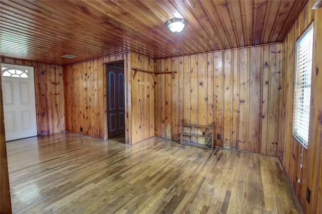 a view of a room with wooden floor and a window