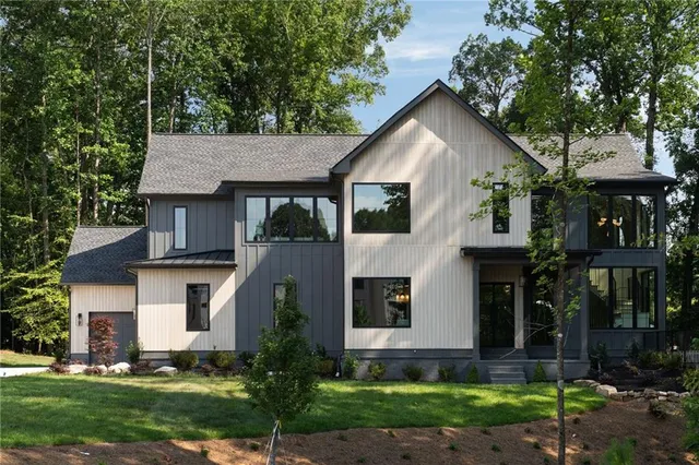 a front view of a house with a yard and trees