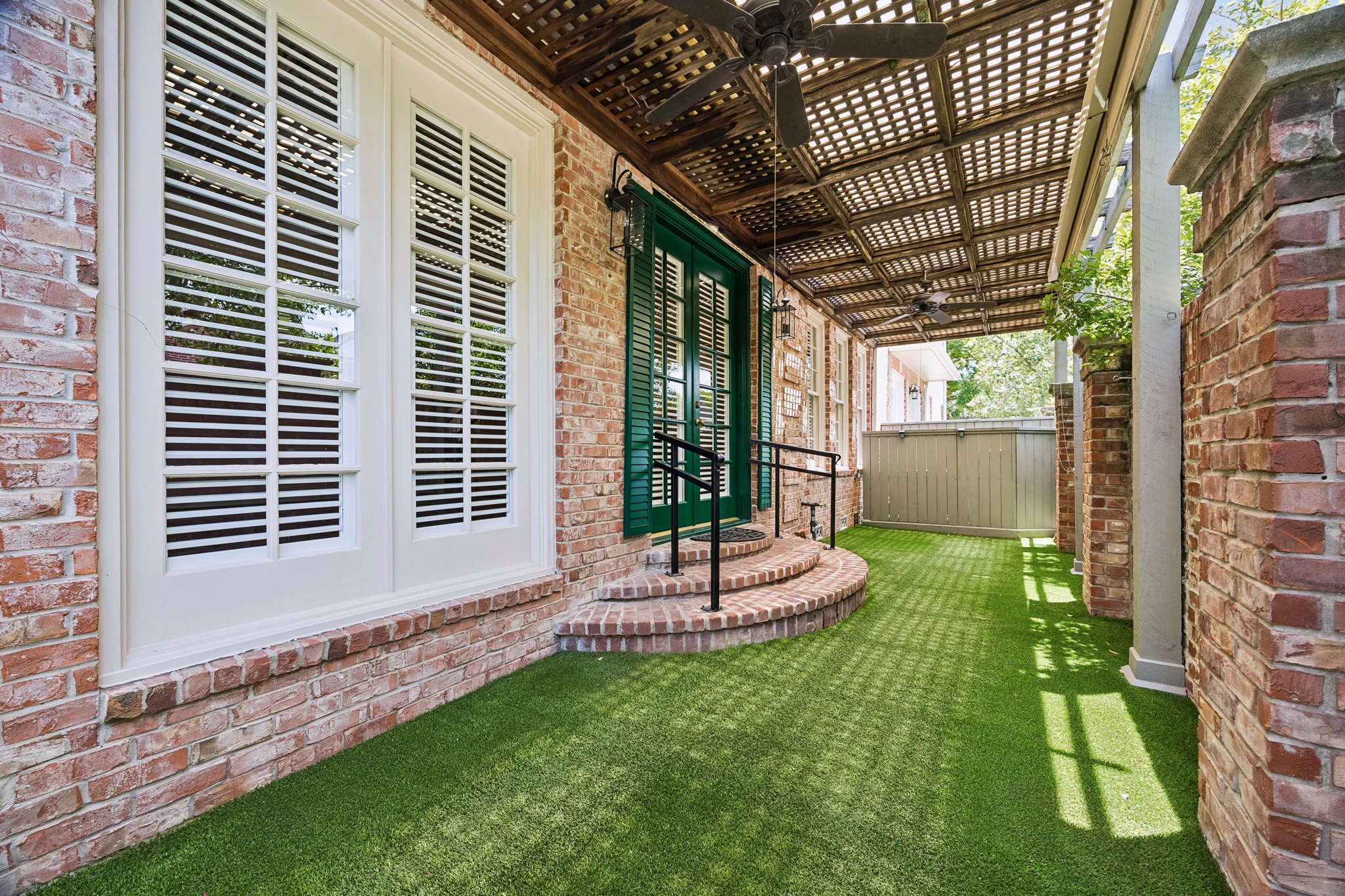 6022 Burgoyne Road Houston, TX 77057 - Photo 24 of 30 Charming brick-walled courtyard offering a private outdoor retreat with mature landscaping and low-maintenance green space.