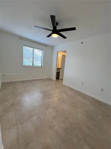 en empty room with windows and ceiling fan