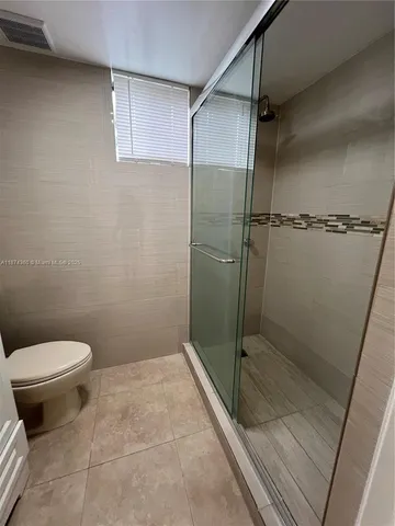a bathroom with a toilet and a shower