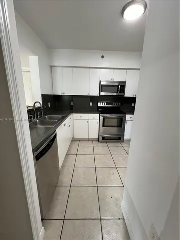 a kitchen with a sink a stove and cabinets