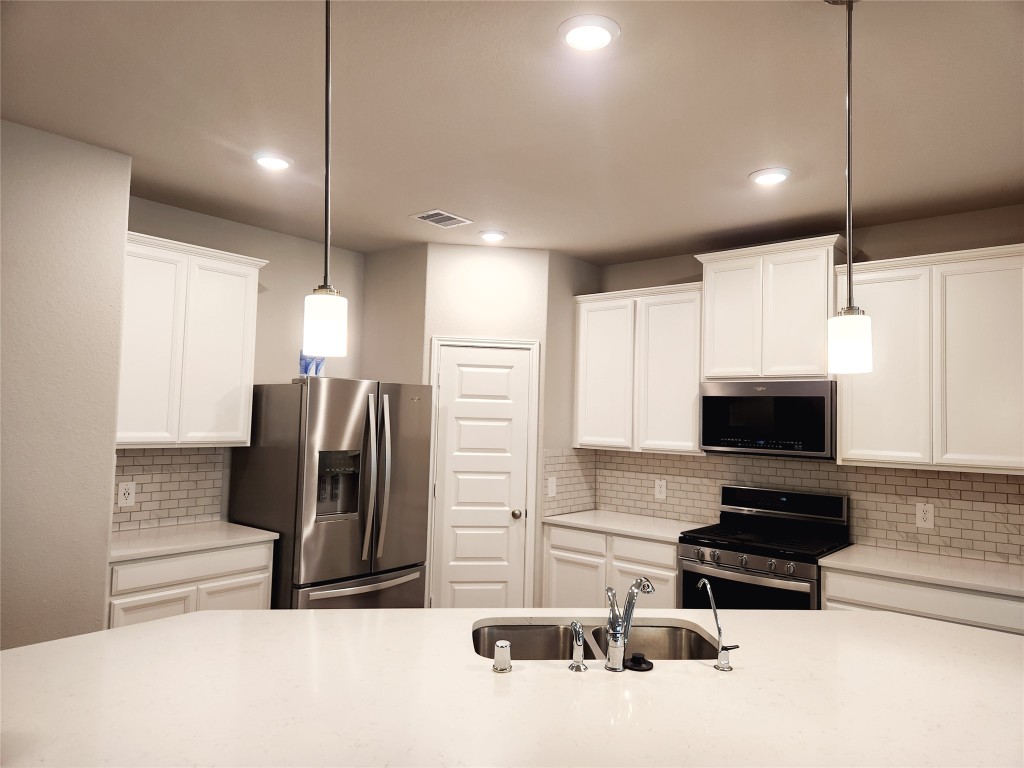 10714 Clfs Vw Drive Rosharon, TX 77583 - Photo 4 of 30 a kitchen with stainless steel appliances a refrigerator a stove a microwave and island