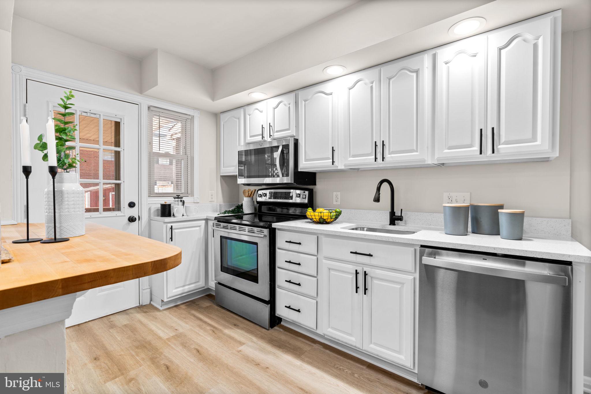 2735 Moorgate Road Dundalk, MD 21222 - Photo 11 of 35 a kitchen with stainless steel appliances white cabinets and wooden floors