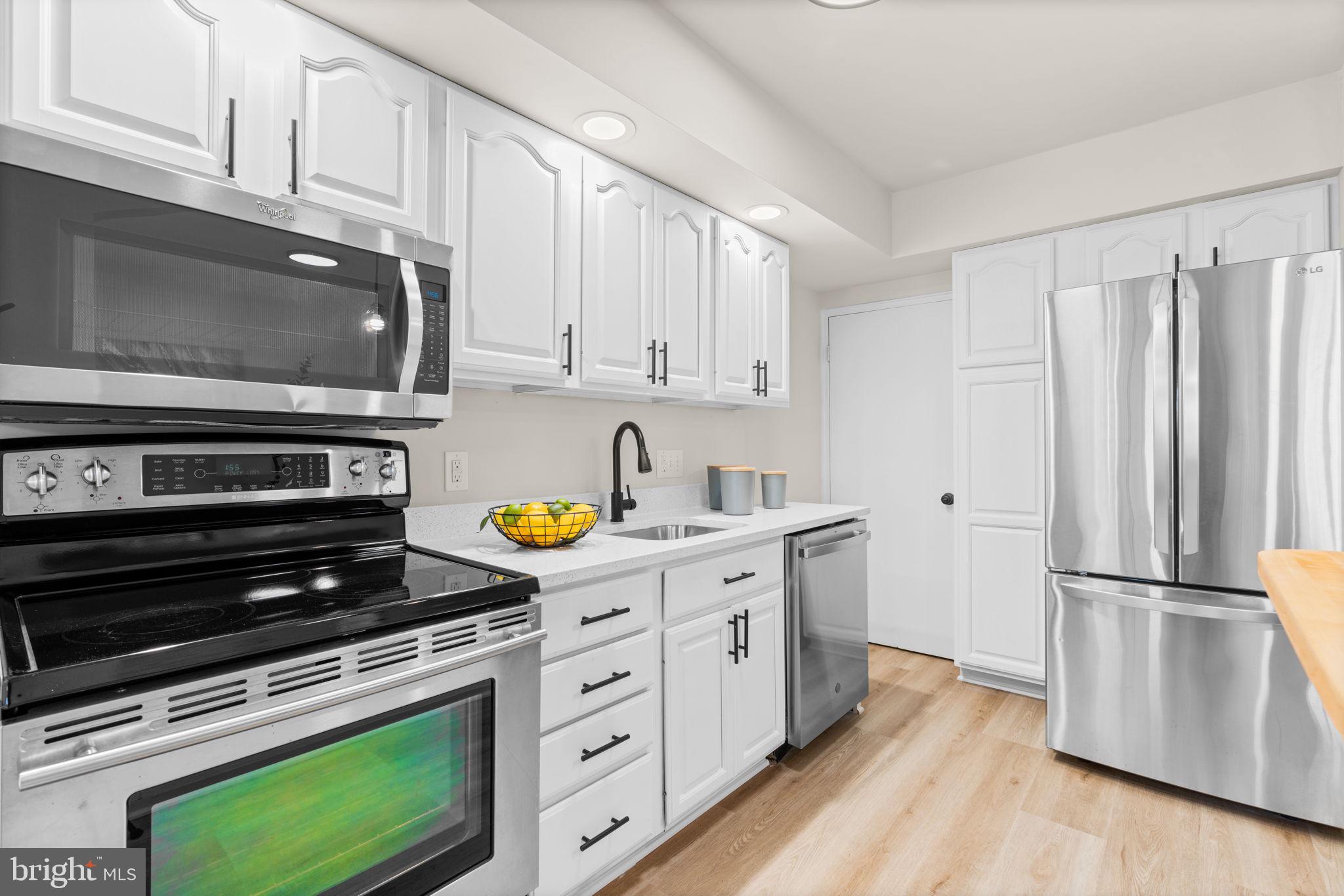 2735 Moorgate Road Dundalk, MD 21222 - Photo 13 of 35 a kitchen with appliances a cabinets and wooden floor