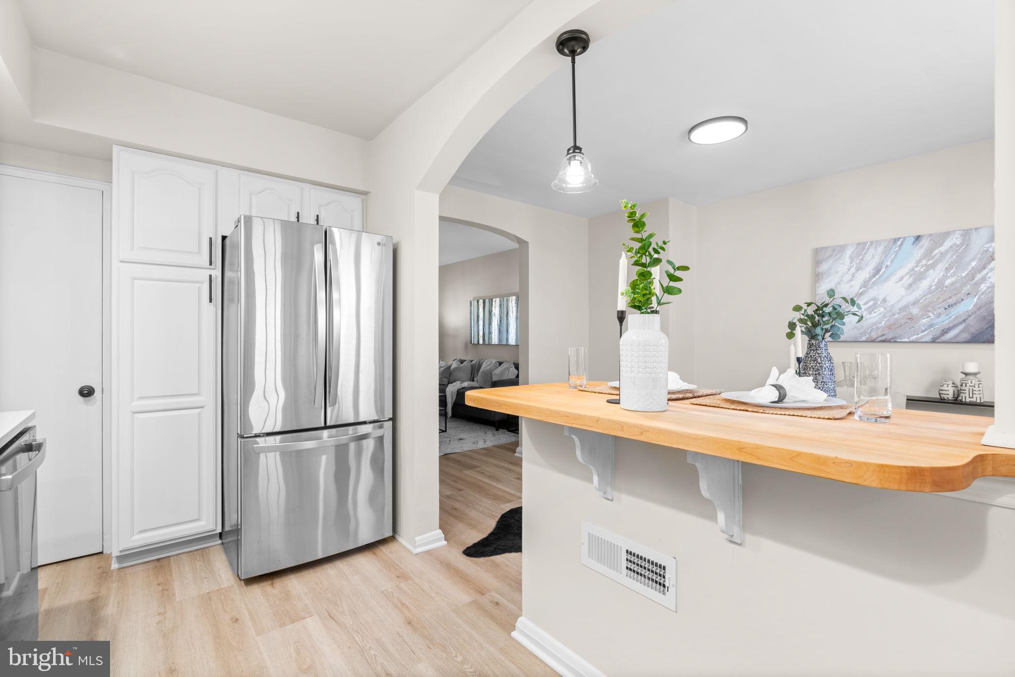 2735 Moorgate Road Dundalk, MD 21222 - Photo 14 of 35 a kitchen with stainless steel appliances granite countertop a refrigerator a sink dishwasher and a stove with wooden floor