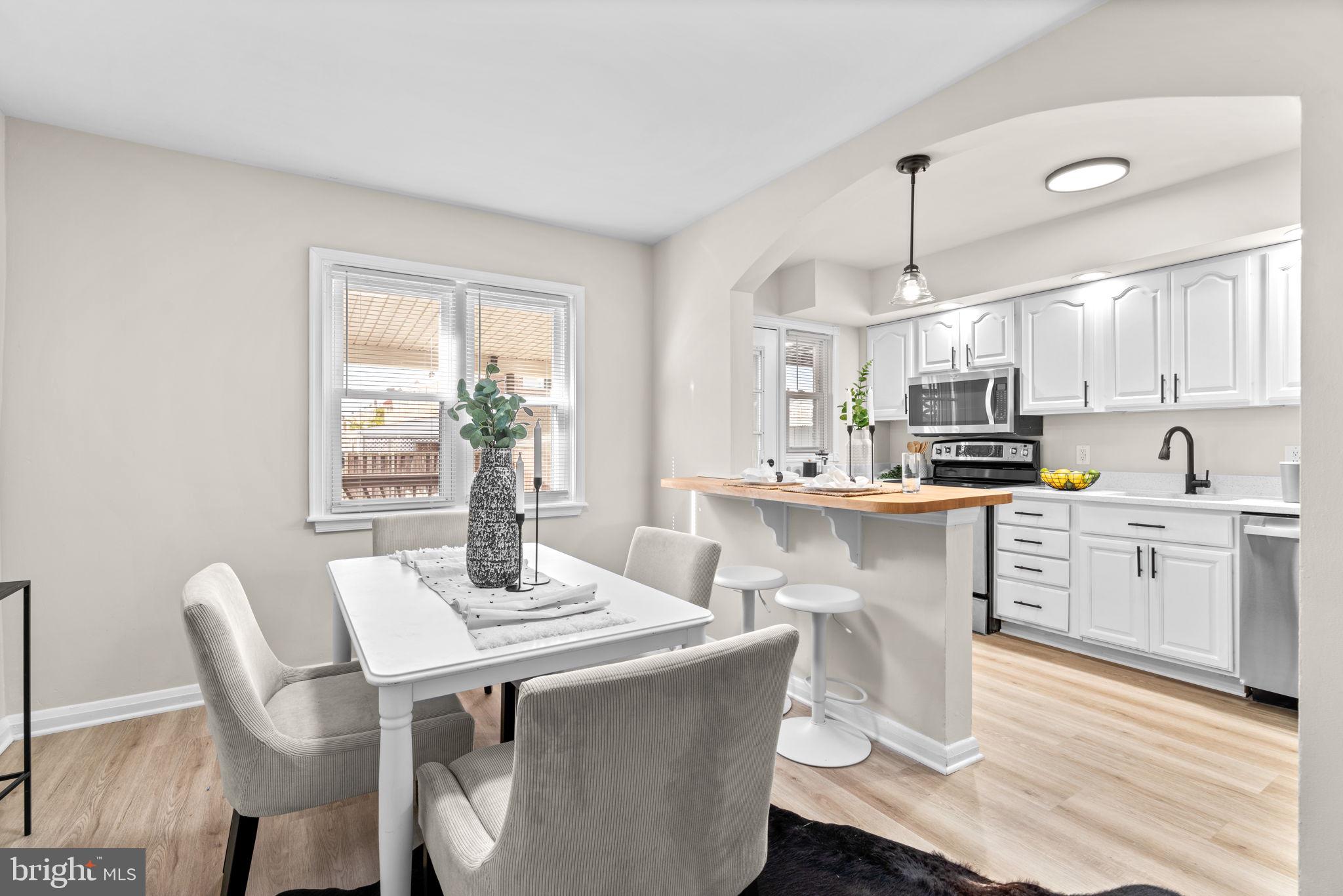 2735 Moorgate Road Dundalk, MD 21222 - Photo 9 of 35 a kitchen with kitchen island a dining table chairs and white cabinets