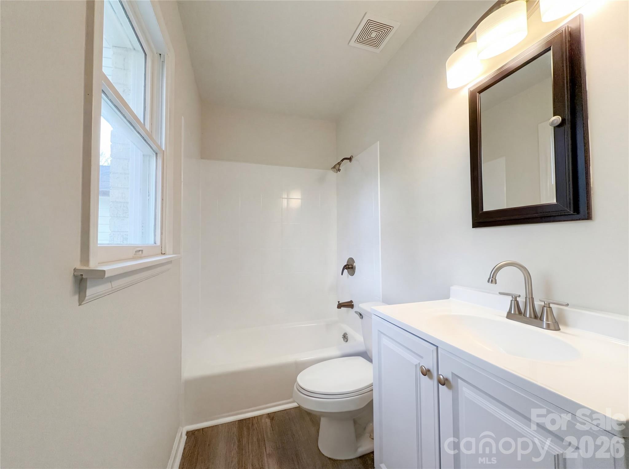 3695 Lake Shore Road South Denver, NC 28037 - Photo 13 of 16 a bathroom with a toilet a sink a mirror and a bathtub