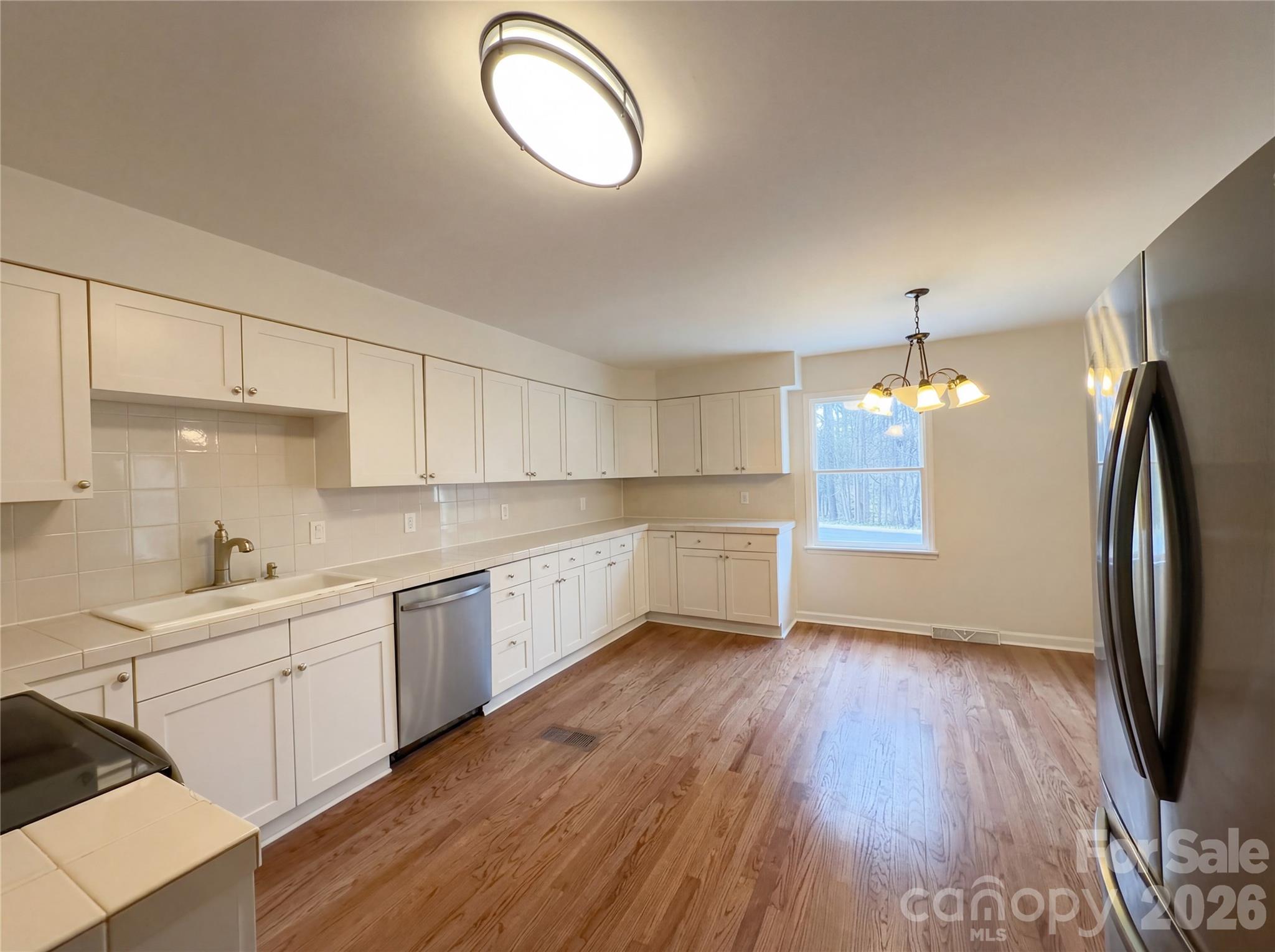 3695 Lake Shore Road South Denver, NC 28037 - Photo 7 of 16 a kitchen with a sink dishwasher a refrigerator cabinets and wooden floor