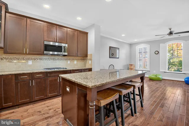 a kitchen with stainless steel appliances granite countertop wooden cabinets a stove top oven a sink and dishwasher