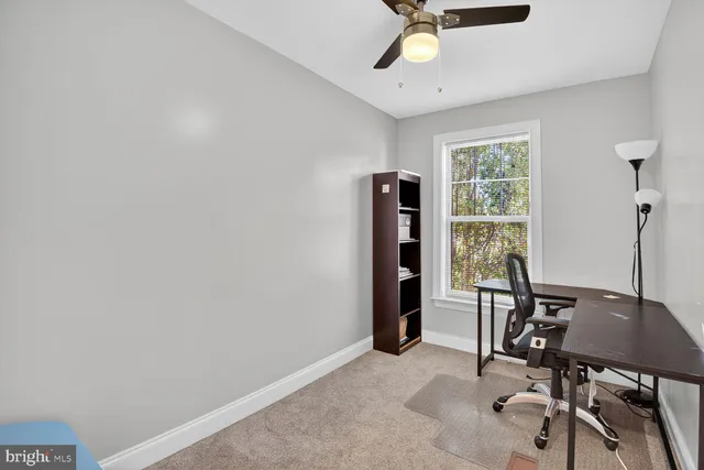 a view of a workspace with furniture and a window