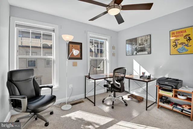 a view of a workspace with furniture and a window