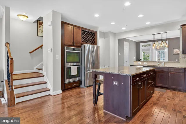 a kitchen with stainless steel appliances granite countertop a refrigerator and a sink