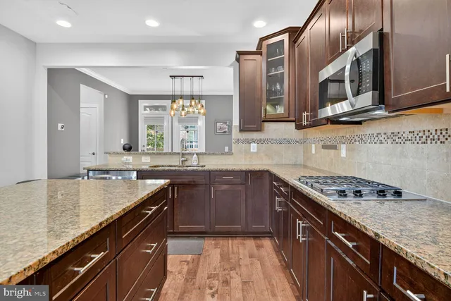 a kitchen with stainless steel appliances granite countertop a sink stove and cabinets