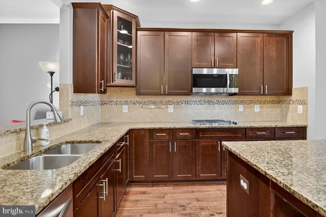 a kitchen with granite countertop stainless steel appliances a sink and cabinets
