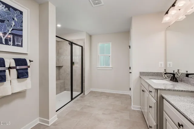 a bathroom with a granite countertop sink a mirror and shower