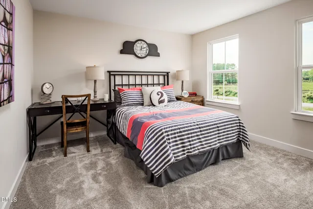 a bedroom with a bed and a table in it next to a window