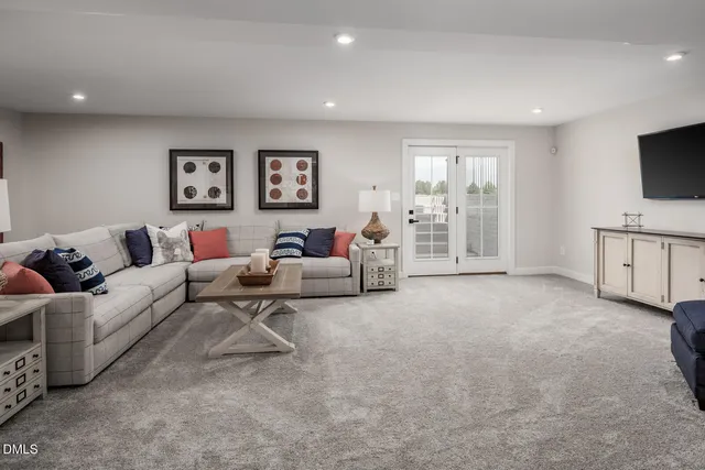 a living room with furniture a flat screen tv and a window