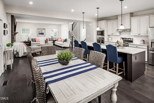 a open kitchen with white cabinets stainless steel appliances and dining table