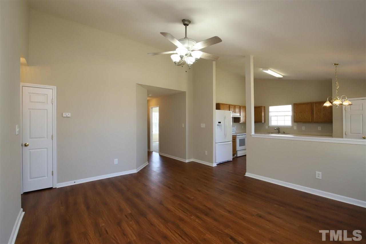 3609 Watkins Ridge Court Raleigh, NC 27616 - Photo 4 of 27 a view of an empty room with wooden floor and a kitchen