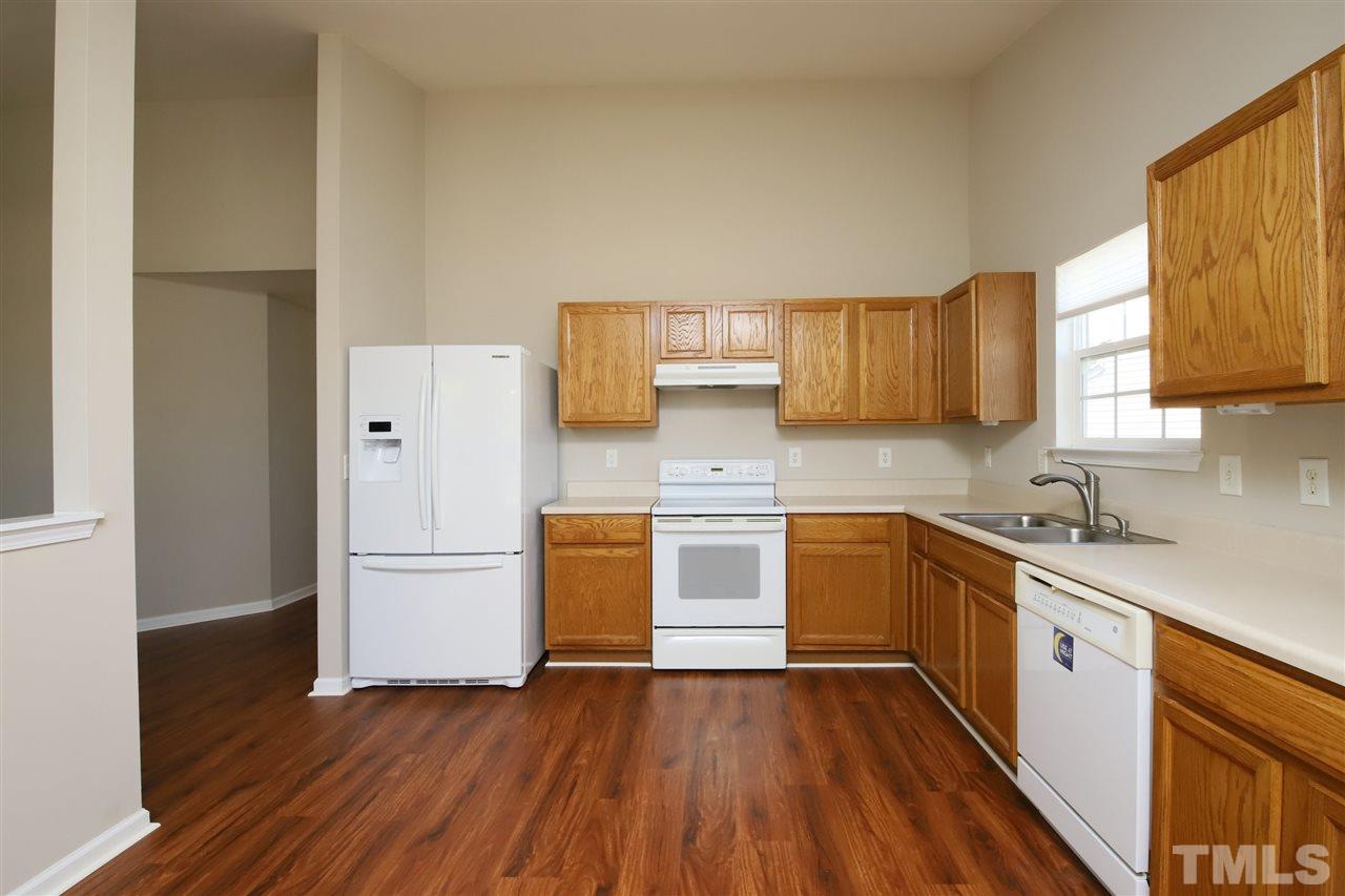 3609 Watkins Ridge Court Raleigh, NC 27616 - Photo 8 of 27 a kitchen with wooden floors and white appliances