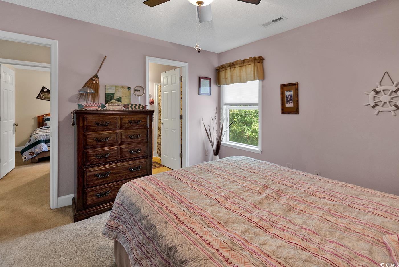 112 Coldstream Cove Loop, Unit 303 Murrells Inlet, SC 29576 - Photo 26 of 39 Bedroom with ensuite bath, light carpet, and ceili
