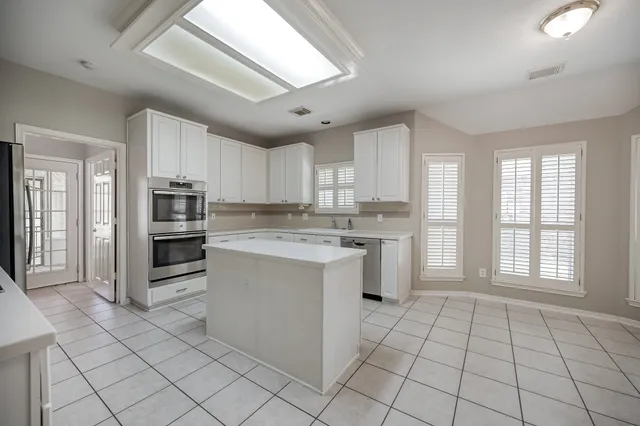 a kitchen with stainless steel appliances granite countertop a stove a sink and a refrigerator
